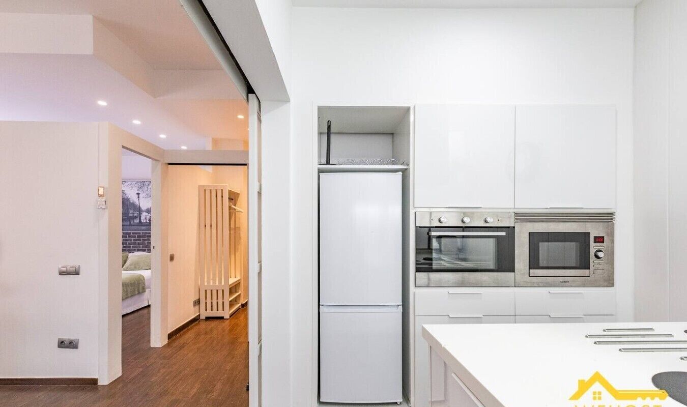 A modern kitchen with a built-in oven, microwave, and refrigerator.