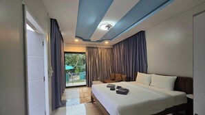 A modern hotel room with a large bed, a view to the outside, and a ceiling with recessed lighting. - Avata Resort Koh Phangan (Ko Pha-ngan)