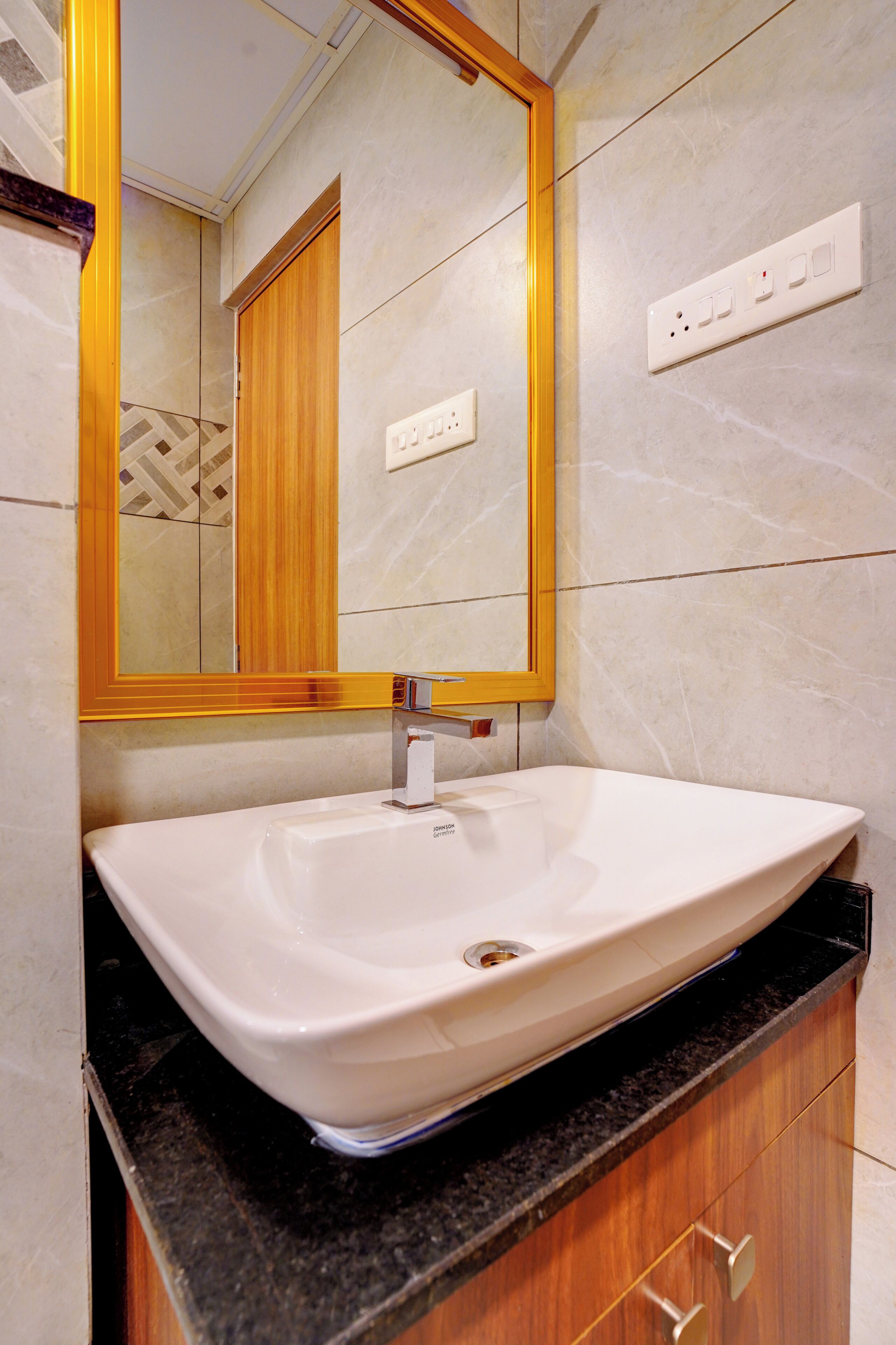 Une salle de bain avec un lavabo blanc, un miroir et un meuble-lavabo en bois.
