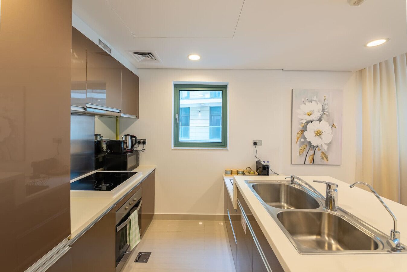 Cocina compacta con estufa, microondas y pileta doble.