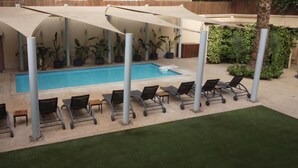A pool area with lounge chairs and a covered seating area. - ICONIA Zamalek (Zamalek)