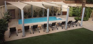 A pool area with lounge chairs and a covered seating area. - ICONIA Zamalek (Zamalek)