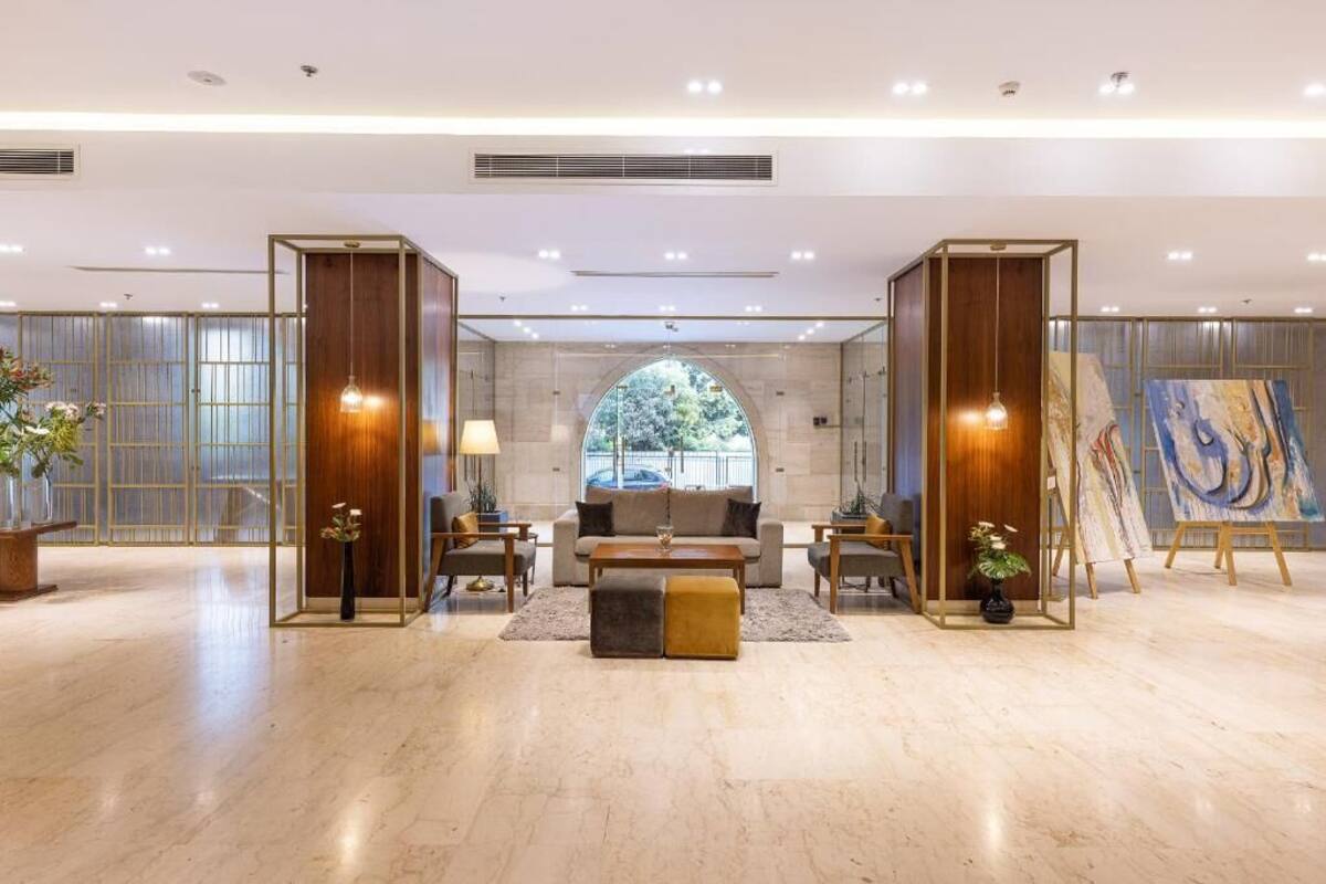 A spacious lobby with a central seating area, a large window, and a painting on display.