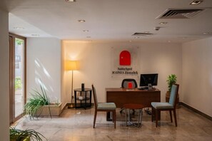 A hotel reception area with a desk, chairs, a lamp, and a sign for 'SuiteSpot ICONIA Zamalek.' - ICONIA Zamalek (Zamalek)