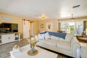 A living room with a white sofa, a coffee table, and a TV on a cabinet. - Heated Pool! Extended Stay 4 Mi to Manasota Beach (Englewood)