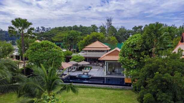 A resort with a swimming pool, outdoor seating, and lush greenery. - Banyan Tree Grand Residences, Four-bedroom Pool Villa (Choeng Thale)