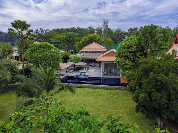 Ein Resort mit Swimmingpool, Sitzgelegenheiten im Freien und üppiger Vegetation.