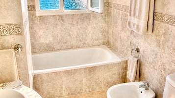Combined shower/bathtub, deep-soaking bathtub, towels
