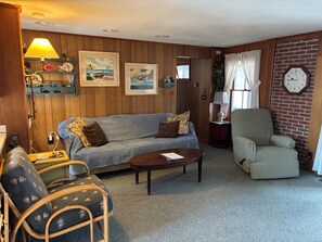 A cozy living room with a sofa, armchair, and a coffee table. - Stay at "Seas the Day" in Ferry Beach, Saco, ME—an inviting 4-bedroom cottage near Camp Ellis (Saco)