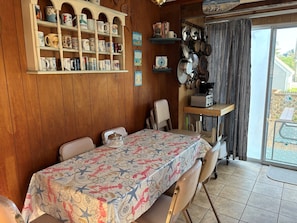 A dining area with a table covered by a patterned tablecloth, surrounded by chairs. - Stay at "Seas the Day" in Ferry Beach, Saco, ME—an inviting 4-bedroom cottage near Camp Ellis (Saco)