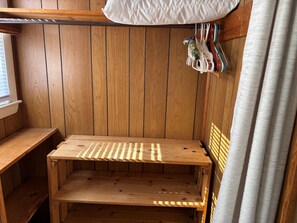 A wooden bench with a slatted seat and backrest, a wooden wall with vertical planks, and a window with blinds. - Stay at "Seas the Day" in Ferry Beach, Saco, ME—an inviting 4-bedroom cottage near Camp Ellis (Saco)