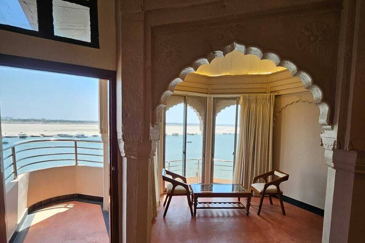 A room with a view of the sea, a balcony, and a traditional arched window.