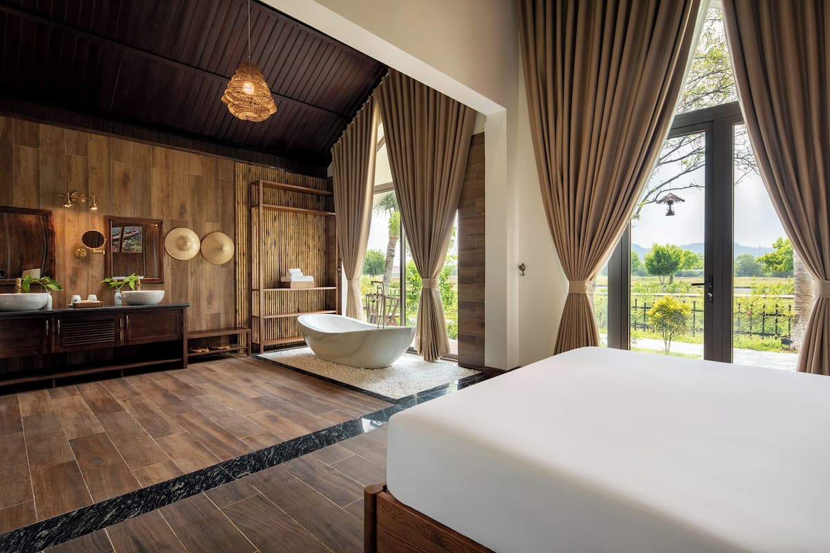 Une salle de bain moderne avec une baignoire sur pieds, un meuble-lavabo en bois et un grand miroir.