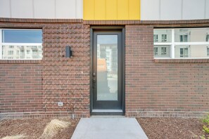 Ein Gebäude mit Backsteinfassade, Glastür und einer gelben Akzentwand.