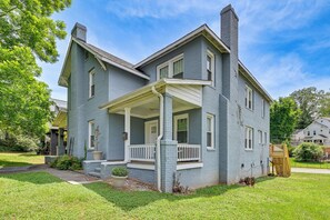 A two-story house with a porch, a chimney, and a well-maintained lawn. - Prime Charlotte Retreat 1 Mi to Uptown! (Charlotte)
