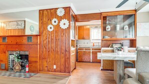 Un intérieur en bois avec une cheminée, un coin repas et une cuisine dotée de meubles en bois.