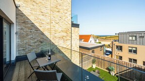 A balcony with a view of the sea, a wooden deck, and a glass railing. - Seascape (Newquay)