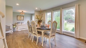 A dining area with a round table, white chairs, and a vase of flowers. - Angler-Friendly Retreat Near Tennessee River (Florence)