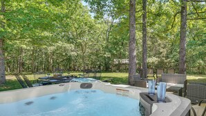 A hot tub surrounded by outdoor furniture, trees, and a grassy area. - Hot Tub, Game Room! Ozarks Family Retreat By Lake (Eldon)