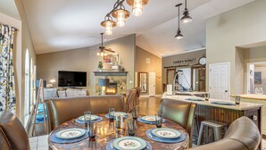 A dining area with a round table set for six, surrounded by leather chairs. - Hot Tub, Game Room! Ozarks Family Retreat By Lake (Eldon)