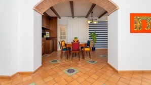 Ein Essbereich mit Ziegelbogen, gestreifter Wand und Tisch mit Stühlen.