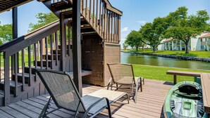 A deck with two chairs, a table, and a kayak. - Lake Conroe Waterfront in Walden! Lovely 4 Bdrm! (Montgomery)