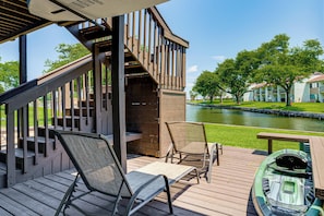 A deck with two chairs, a table, and a kayak. - Lake Conroe Waterfront in Walden! Lovely 4 Bdrm! (Montgomery)