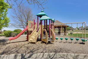 Ein Spielplatz mit Rutsche, Kletterbereich und Schaukeln.