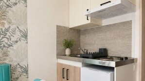 Uma cozinha compacta com fogão, geladeira e um pequeno balcão.