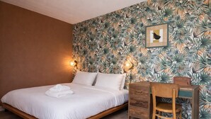 Une chambre à coucher avec un lit, des lampes de chevet, un bureau et une chaise.