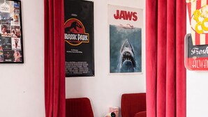 A bedroom with a bed, two red chairs, a small white table, and posters on the wall. - Comfortable apartment for 2 guests in the historic district - Cinema getaway (Angers)