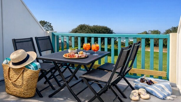 A patio with a table set for a meal, outdoor chairs, a woven basket, and a pair of sunglasses. - Sea and port view apartment - Golf of Bourgenay - 6 people (Talmont-Saint-Hilaire)
