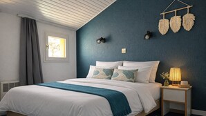 A bedroom with a bed, a bedside table with a lamp, a window with curtains, and a wall with decorative elements. - Sea and port view apartment - Golf of Bourgenay - 6 people (Talmont-Saint-Hilaire)