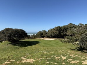 A golf course with a clear view of the ocean, surrounded by dense trees. - Sea and port view apartment - Golf of Bourgenay - 6 people (Talmont-Saint-Hilaire)