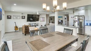 A spacious kitchen with a central island, modern appliances, and a dining area with a wooden table and chairs.