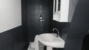 A modern bathroom with a white sink, a shower, and a toilet. - Comfortable and cozy studio – 2 people – La Doutre district, Angers (Angers)