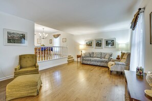 Ein geräumiges Wohnzimmer mit Holzboden, einer Treppe und einem Essbereich.