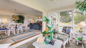 A spacious room with wicker furniture, a large window, and a decorative plant centerpiece. - On the ICW: Personal Dock, Ocean Fishing & Beach! (Newport)
