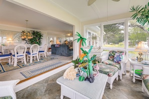 A spacious room with wicker furniture, a large window, and a decorative plant centerpiece. - On the ICW: Personal Dock, Ocean Fishing & Beach! (Newport)