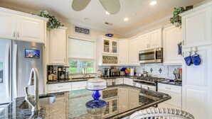 A modern kitchen with white cabinetry, stainless steel appliances, and a central island. - On the ICW: Personal Dock, Ocean Fishing & Beach! (Newport)