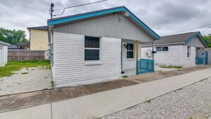A single-story house with a front porch, a small attached garage, and a gravel driveway. - 6 Mi to TMC & Hermann Park! SE Houston Home (Houston)