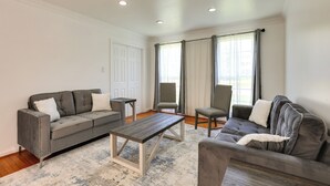 Ein Wohnzimmer mit grauem Sofa, einem Couchtisch und zwei Sesseln.