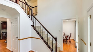 Eine Treppe mit Holzbalkon und weißen Wänden.