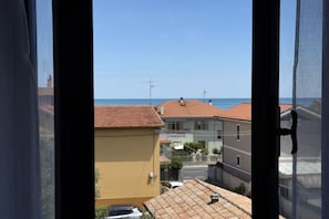 Una zona residencial costera con edificios, cielo despejado y vista al mar.