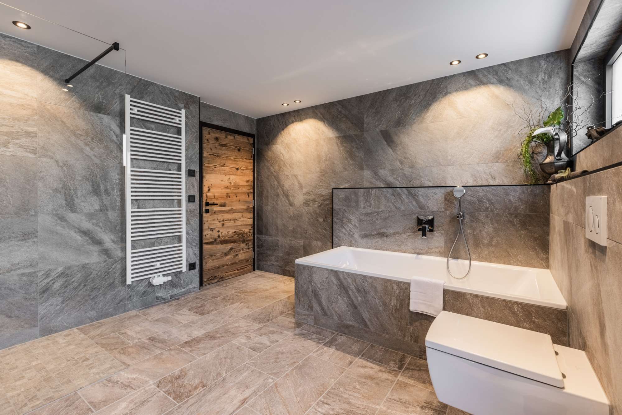 Une salle de bain moderne équipée d’une douche, de toilettes et d’un lavabo.