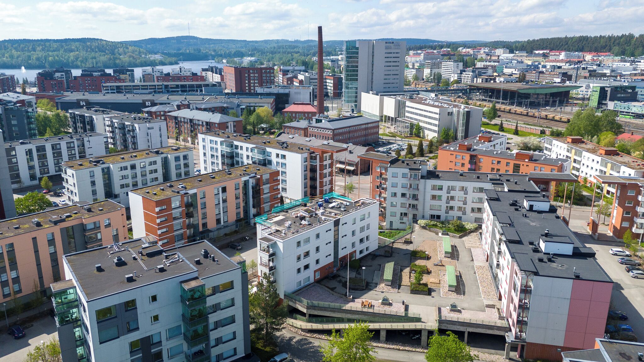 Un immeuble de grande hauteur, avec de nombreux étages, un espace de stationnement et une rivière en arrière-plan.