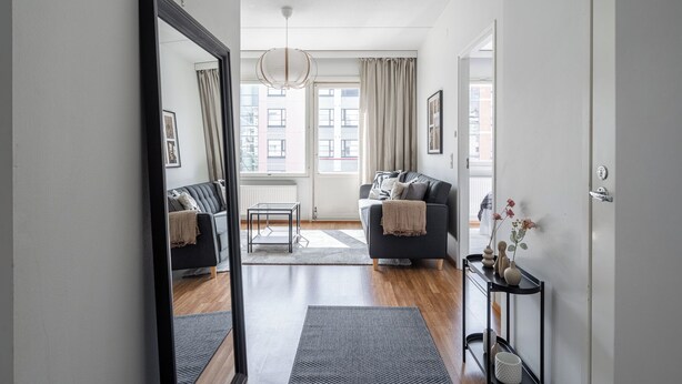 A modern living room with a sofa, a coffee table, and a console table with decorative items. - Comfy 1BR Apt with Sauna - Best Location (Jyväskylä)