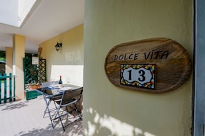 Ein hölzernes Schild mit der Aufschrift 'DOLCE VITA 13' und einem farbenfrohen Schild mit der Nummer 13.