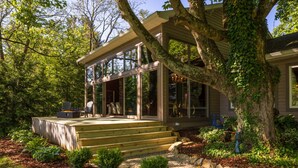 A modern house with a large deck, a stone fireplace, and a well-maintained garden. - An Artist's Story: A Private Sanctuary-devoted to art and quiet poetry..... (Logan)