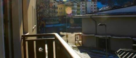 A balcony with a view of a mountain and buildings.